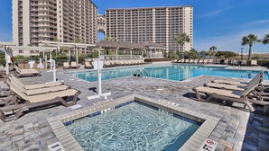 A hotel pool area with lounge chairs and a clear view of the building's exterior. - Oceanfront Premium 3BR- Gourmet Kitchen! Farmhouse Decor! Gorgeous View! (Myrtle Beach)