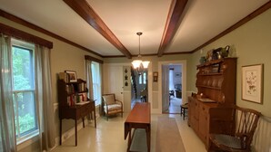 Une salle à manger spacieuse, avec une table et des chaises en bois, une bibliothèque et une vue sur le salon attenant.