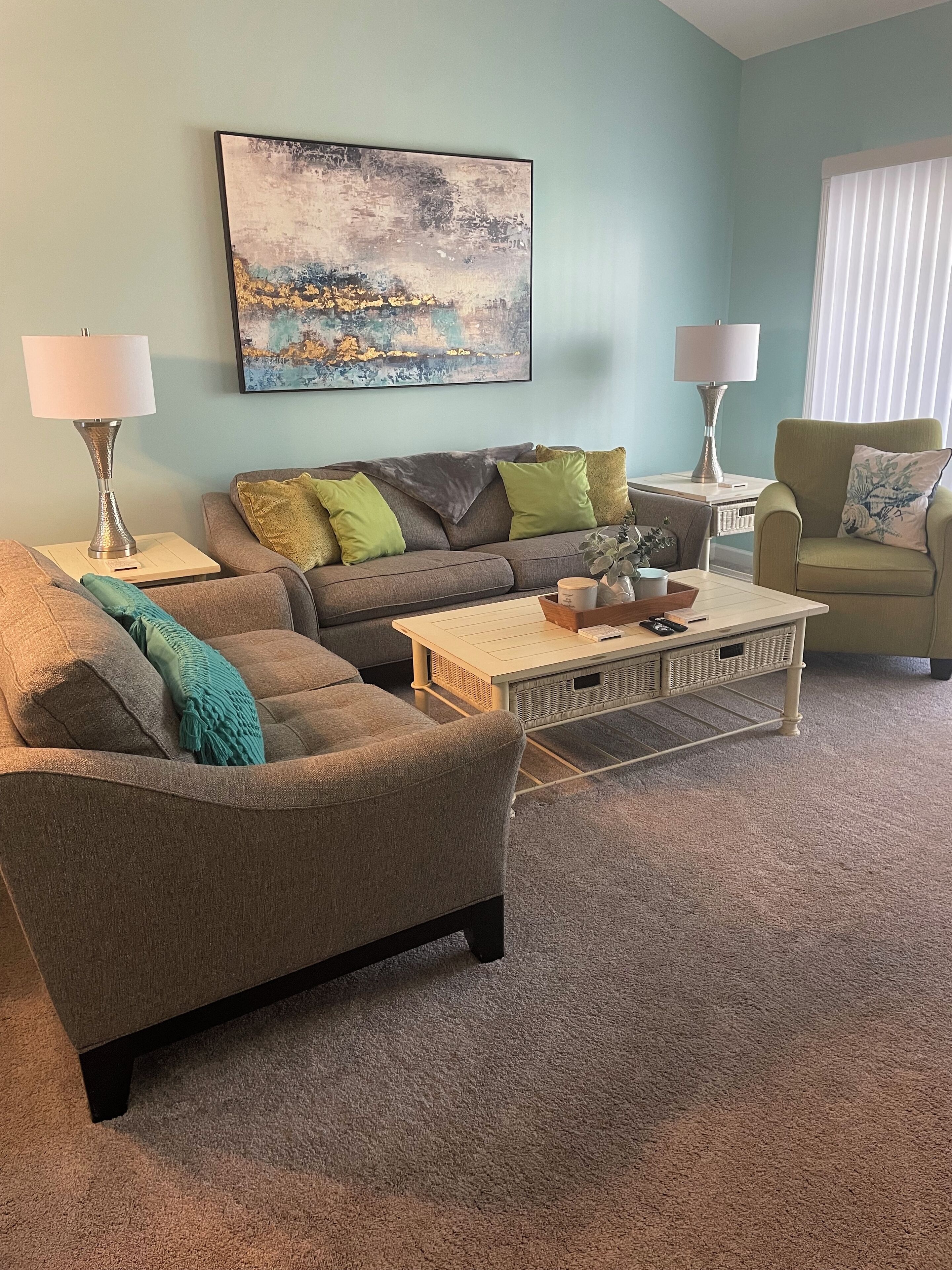 A living room with a grey sofa, a coffee table, and two lamps.