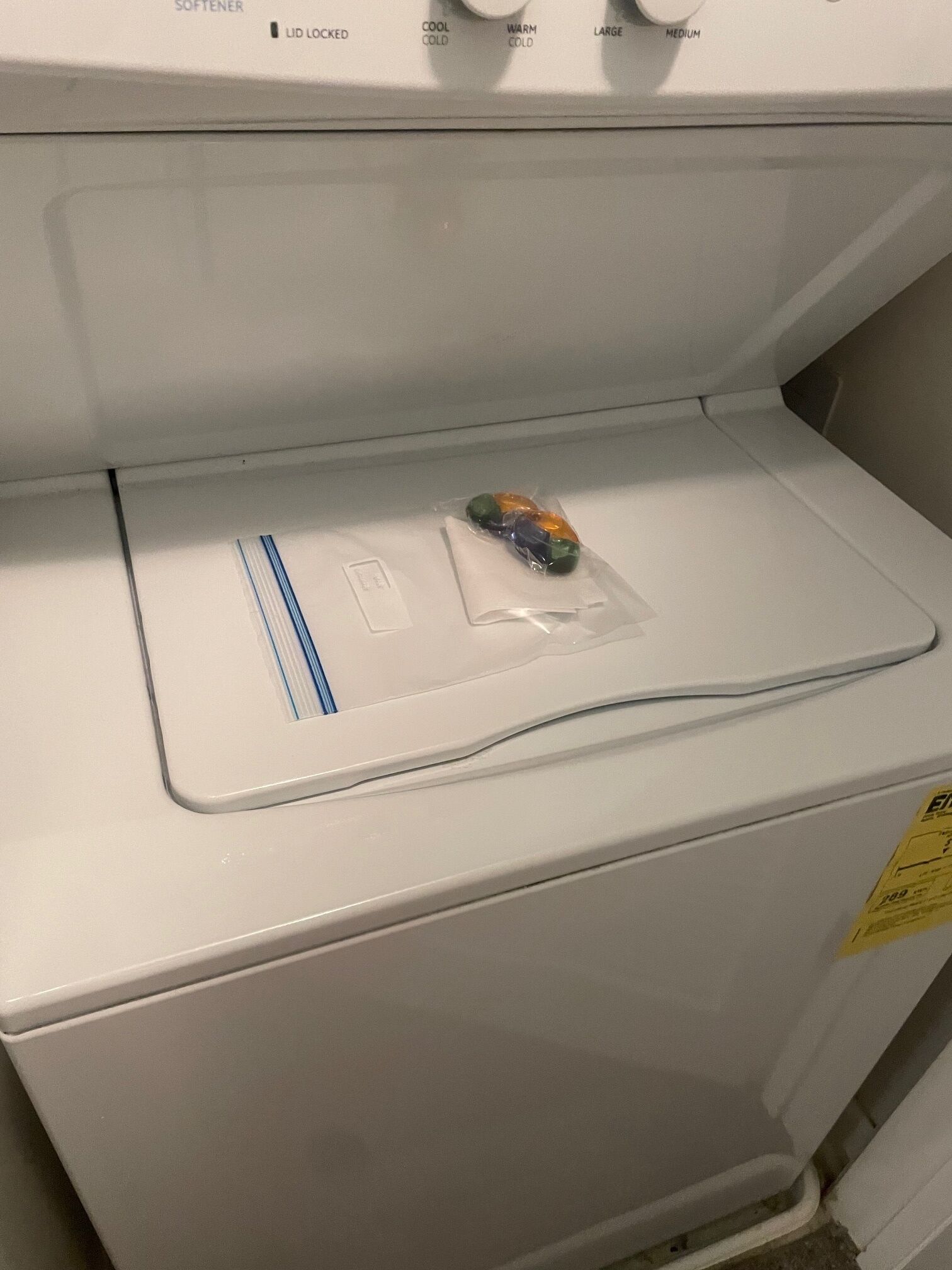 Un lave-linge à chargement frontal doté d’un panneau de commande offrant les options suivantes : adoucisseur, verrouillage, programme « froid », programme « tiède », programme pour les gros articles et programme pour les articles de taille moyenne.