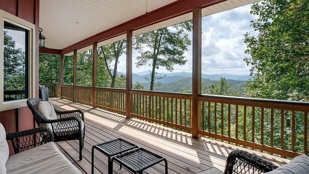 A covered deck with wicker furniture, a view of trees and mountains, and a wooden railing. - Red Rooster Retreat,Hot Tub+game area+firepit & LRG deck w/amazing Mountain View (Franklin)