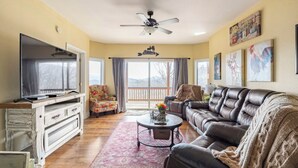 A living room with a television, sofa, armchair, and a ceiling fan. - Red Rooster Retreat,Hot Tub+game area+firepit & LRG deck w/amazing Mountain View (Franklin)
