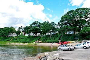 A lakeside scene with houses, a sandy beach, and parked cars. - Ocean View Cottage Falmouth Foreside (Falmouth)