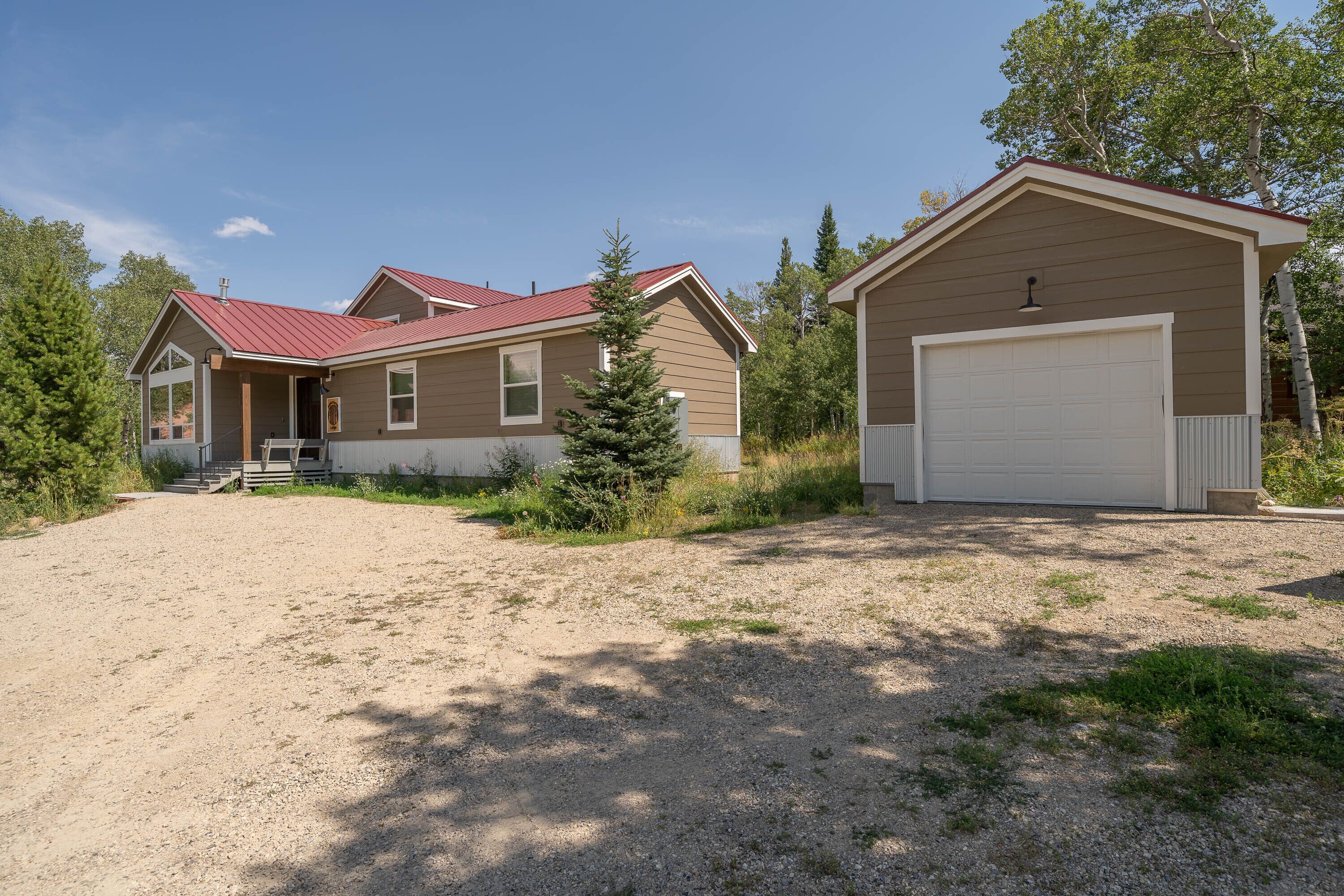 A two-story house with a red roof, a garage, and a covered porch.