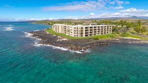 A beachfront hotel with multiple floors, a pool, and a view of the ocean. - Live On the Ocean and Sleep to Surf Sounds in Idyllic Poipu. Trade Winds & AC.
 (Poipu)