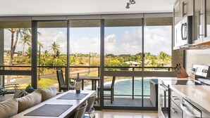 A modern kitchen with a view of the ocean and palm trees. - Live On the Ocean and Sleep to Surf Sounds in Idyllic Poipu. Trade Winds & AC.
 (Poipu)