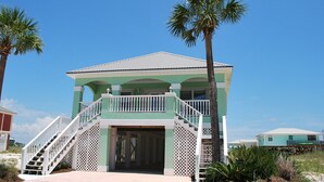A two-story building with a green facade, white railings, and a central door. - Oh the views, hear the surf Great location all year long (Gulf Shores)