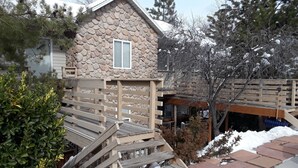 A stone cabin with a wooden deck and a small staircase leading to a window. - Luxury Townhouse at the Gateway to the Utah Canyons, Best Price On VRBO! (Cottonwood Heights)