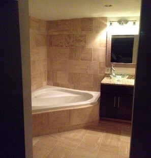 Un baño con bañera, lavamanos y espejo.