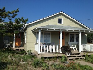 A single-story house with a front porch, a small window, and a door. - The Surf Shack,Charming historic cottage, steps to the beach, Nags Head MP 11 (Nags Head)