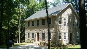 A stone building with a symmetrical facade, multiple windows, and a central entrance.