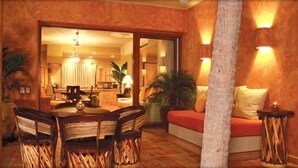 Un lobby de hotel acogedor con zona de comedor, un sofá y un espejo grande.