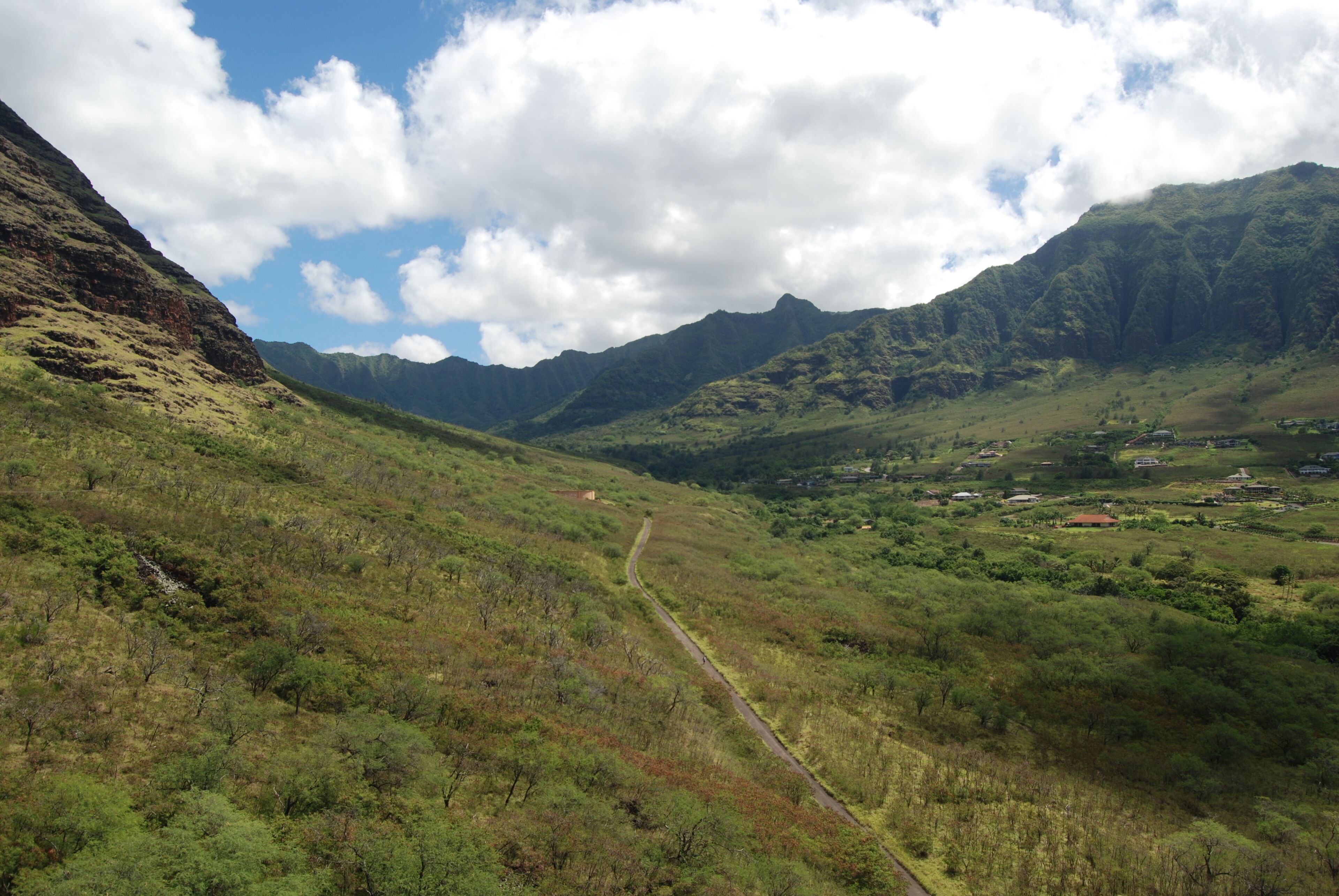 A mountainous landscape with a winding path leading through a valley.