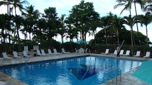 A swimming pool with lounge chairs and palm trees in the background. - Affordable Luxury, Gorgeous One Bedroom Condo, Amazing Views and Great WiFi (Waianae)
