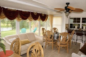 A sunroom with a dining area, a sofa, and chairs. - Hudson Waterfront Home in Beacon Woods Community W/ Access to Club Amenities (Bayonet Point)