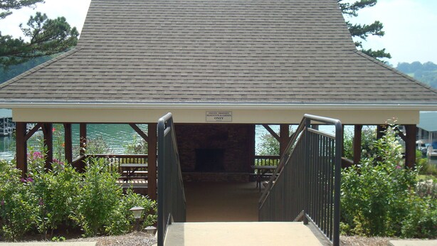 A covered pavilion with a ramp leading to a bench and a sign indicating private property.