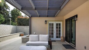 A covered patio area with a sofa, a small table, and a bench. - Prime Montecito Beach Location (Montecito)