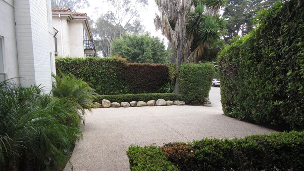 A well-maintained garden with a paved pathway, neatly trimmed hedges, and a variety of plants. - Prime Montecito Beach Location (Montecito)