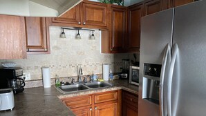 A kitchen with wooden cabinets, stainless steel appliances, a double sink, and a built-in oven.