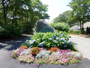 A well-maintained garden with a prominent rock inscribed with 'Fells Pond' and 'New Shady'.