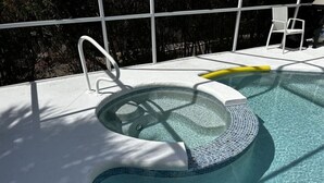 Ein Swimmingpool mit Whirlpool, einer Leiter und einem Stuhl.