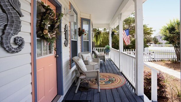 A porch with wicker chairs, a decorative rug, and an American flag. - Private Pool, Small pets welcome, walk to beach, bikes and golf cart included (Destin)