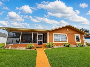 A single-story house with a covered porch, a front yard with a pathway, and a clear blue sky. - Luxurious Waterfront Holiday Home with Fully Encompassing Lakeview (Holiday)