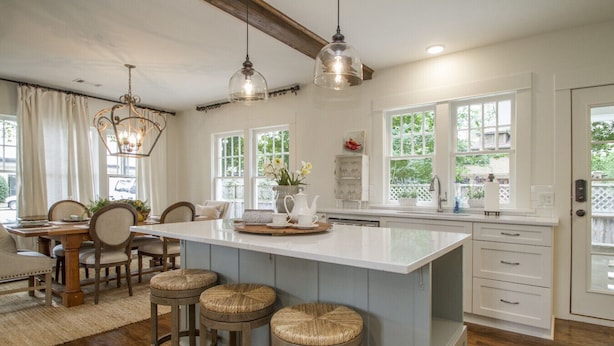 A spacious kitchen with a large island, wooden bar stools, and pendant lighting. - Historic Southern Cottage close to Downtown Conway (Conway)