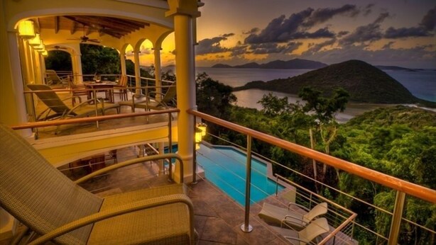 A poolside area with lounge chairs and a view of the sea at dusk. - Villa Sirenetta-Minutes from the beach! (Tortola)