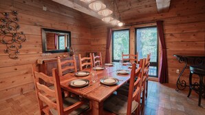 A wooden dining room with a long table set for six, surrounded by wooden chairs. - Tahoe Lodge Style Ambiance, Dog Friendly with Hottub, Sauna & Fenced Yard. By Tahoe Time VR (Tahoe City)