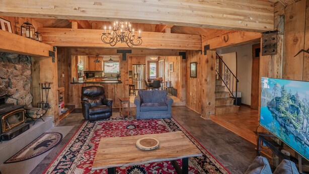A spacious living area with a fireplace, leather armchair, and a large TV. - Tahoe Lodge Style Ambiance, Dog Friendly with Hottub, Sauna & Fenced Yard. By Tahoe Time VR (Tahoe City)