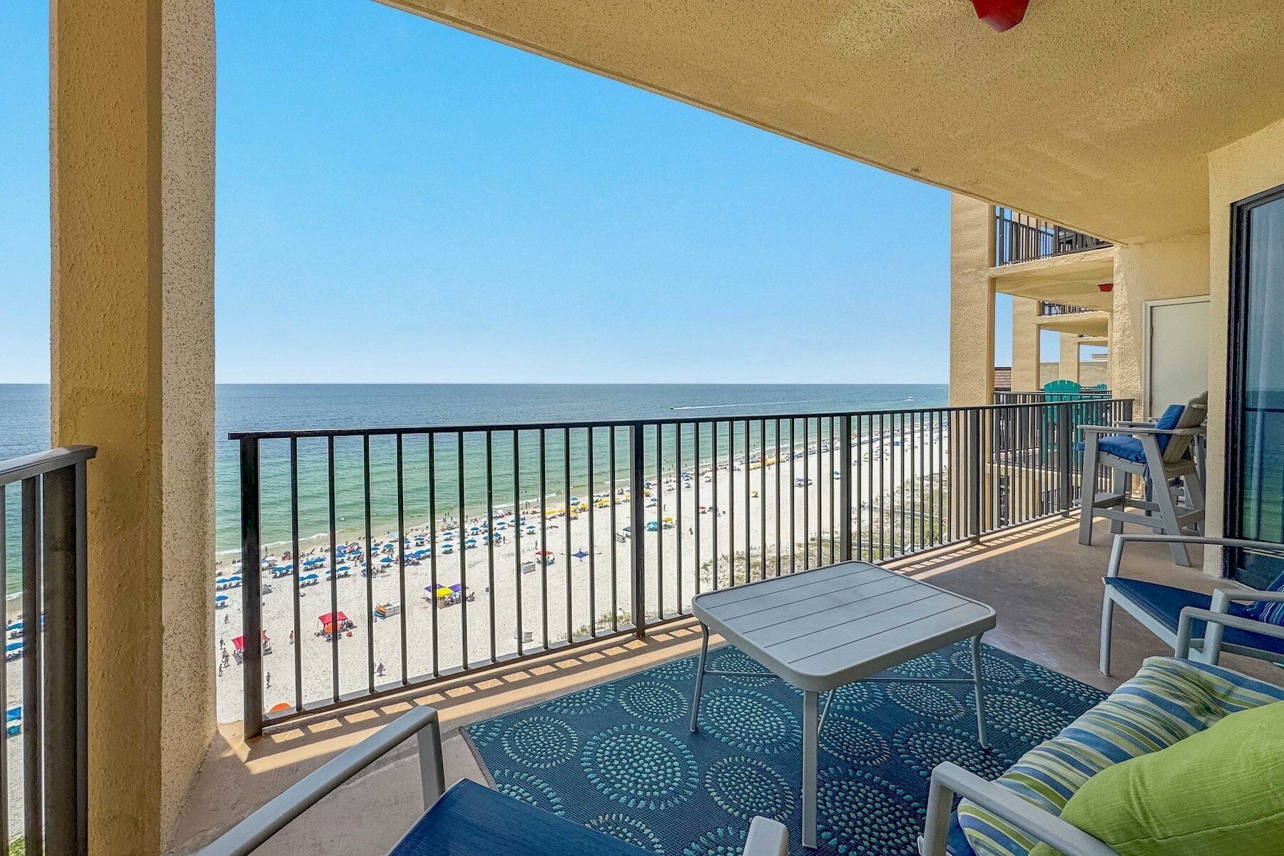 A balcony with a view of a beach and ocean.