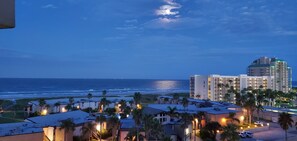 A resort with beachfront views, multiple buildings, and palm trees.