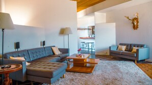 A modern living room with a sectional sofa, a coffee table, and a decorative wall piece. - Family-Friendly Beautiful Private Wellness Retreat / Desert Oasis (Scottsdale)