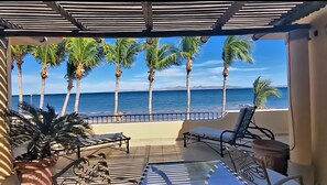 A covered outdoor seating area with a view of the ocean and palm trees. - Escape To An Ocean Front Five Star Paradise : A 10 minute walk into Loreto (Loreto)