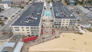 A coastal hotel with a pool, beach access, and a boardwalk with outdoor seating. - Downtown Dewey Beach Ocean/Bay Views 2BR Pools Fire Pit (Rehoboth Beach)