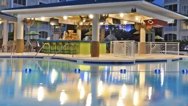 A pool area with a covered bar and lounge chairs. - South Beach Resort-Beautiful Beach Resort for Family Fun!! (Myrtle Beach)