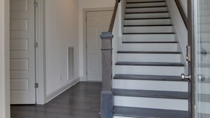 A staircase with wooden steps and a metal handrail, leading to a door at the top. - Music Centric Home, 5 minutes to Broadway. (Nashville)