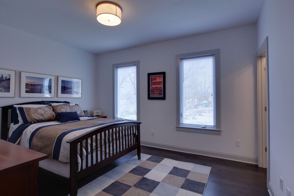 A bedroom with a bed, a nightstand, a dresser, and two windows with blinds. - Music Centric Home, 5 minutes to Broadway. (Nashville)