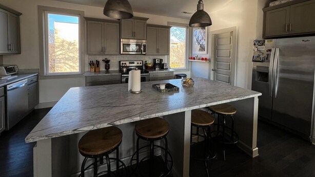 A modern kitchen with a large island, stainless steel appliances, and pendant lighting. - Music Centric Home, 5 minutes to Broadway. (Nashville)