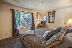 Une chambre avec un grand lit, un bureau, une chaise et un téléviseur.