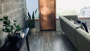 A modern living room with a sliding door, a sofa, a coffee table, and two potted plants. - Architectural dream guest house (Phoenix)