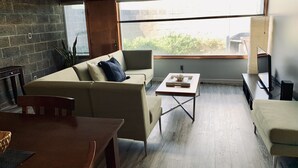 A modern living room with a sofa, coffee table, and TV stand. - Architectural dream guest house (Phoenix)