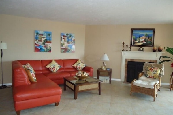 Living room w/ wood burning fireplace, 52" TV, opens to balcony and dining area.