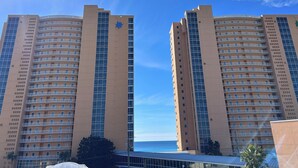 Two high-rise buildings with balconies, a clear sky, and a view of the ocean. - Corner Condo - Stunning Gulf Views -Comp. Beach Service, Water Park & Lazy River (Panama City Beach)