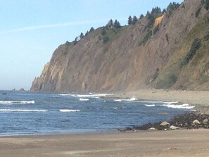 Un paisaje costero con un acantilado rocoso y una playa.