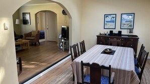 A dining area with a striped tablecloth, wooden chairs, and a television in the background. - Manzanita Beach Charmer! Dog Friendly Home with a Short Walk to Beach ~MCA#1012 (Manzanita)