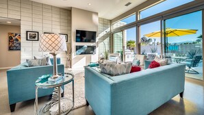 A modern living room with two sofas, a glass coffee table, and a TV. - PS Paradise: Contemporary Modern Home; Large with Modern Comforts (Palm Springs)