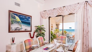 A dining area with a glass table, chairs, and a view of the ocean. - Two Story, 5 Bedroom Penthouse On Tamarindo Beach- New  (Tamarindo)