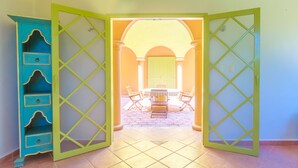 Una habitación con un separador verde, un armario azul y un piso de baldosas.